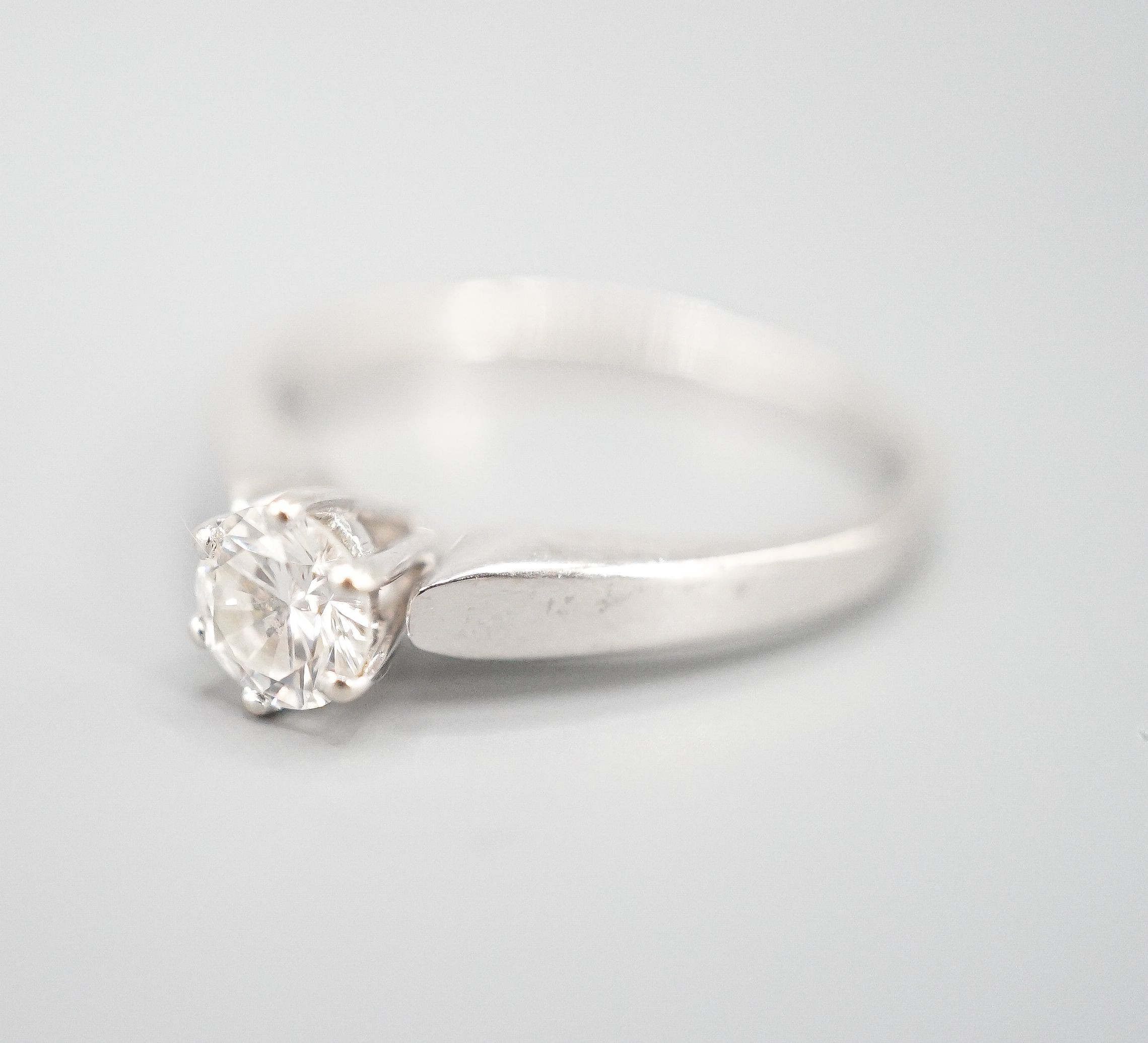 A modern white metal and solitaire diamond ring, size M, gross weight 2.3 grams.